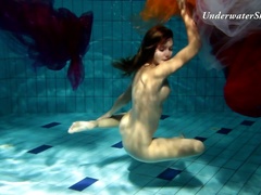 Fire redhead girl named Edwige swimming naked in a pool