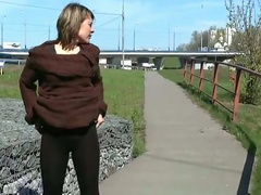 Nasty brunette beauty pisses near the highway on a sunny day